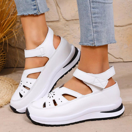 White cutout Mary Jane shoes with adjustable ankle strap, low heel, PU leather material, rubber sole, and casual everyday styling.