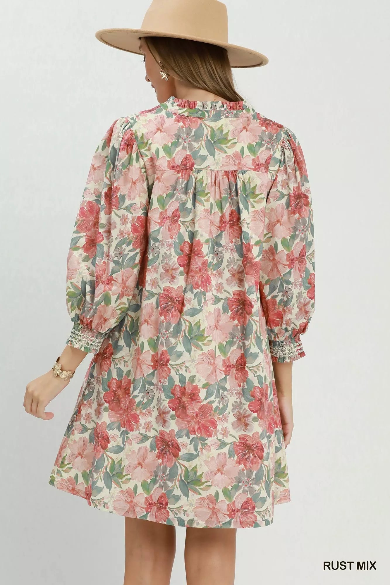 Floral mini dress with smocked cuffs, relaxed flowy fit, lined body, and soft mixed floral print styled with a sun hat.