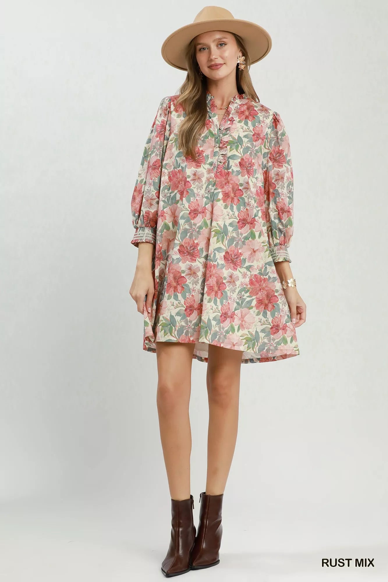 Floral mini dress with smocked cuffs, relaxed flowy fit, lined body, and soft mixed floral print styled with a sun hat.