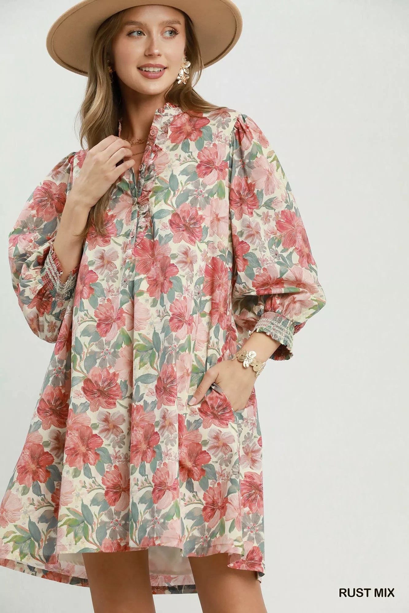 Floral mini dress with smocked cuffs, relaxed flowy fit, lined body, and soft mixed floral print styled with a sun hat.