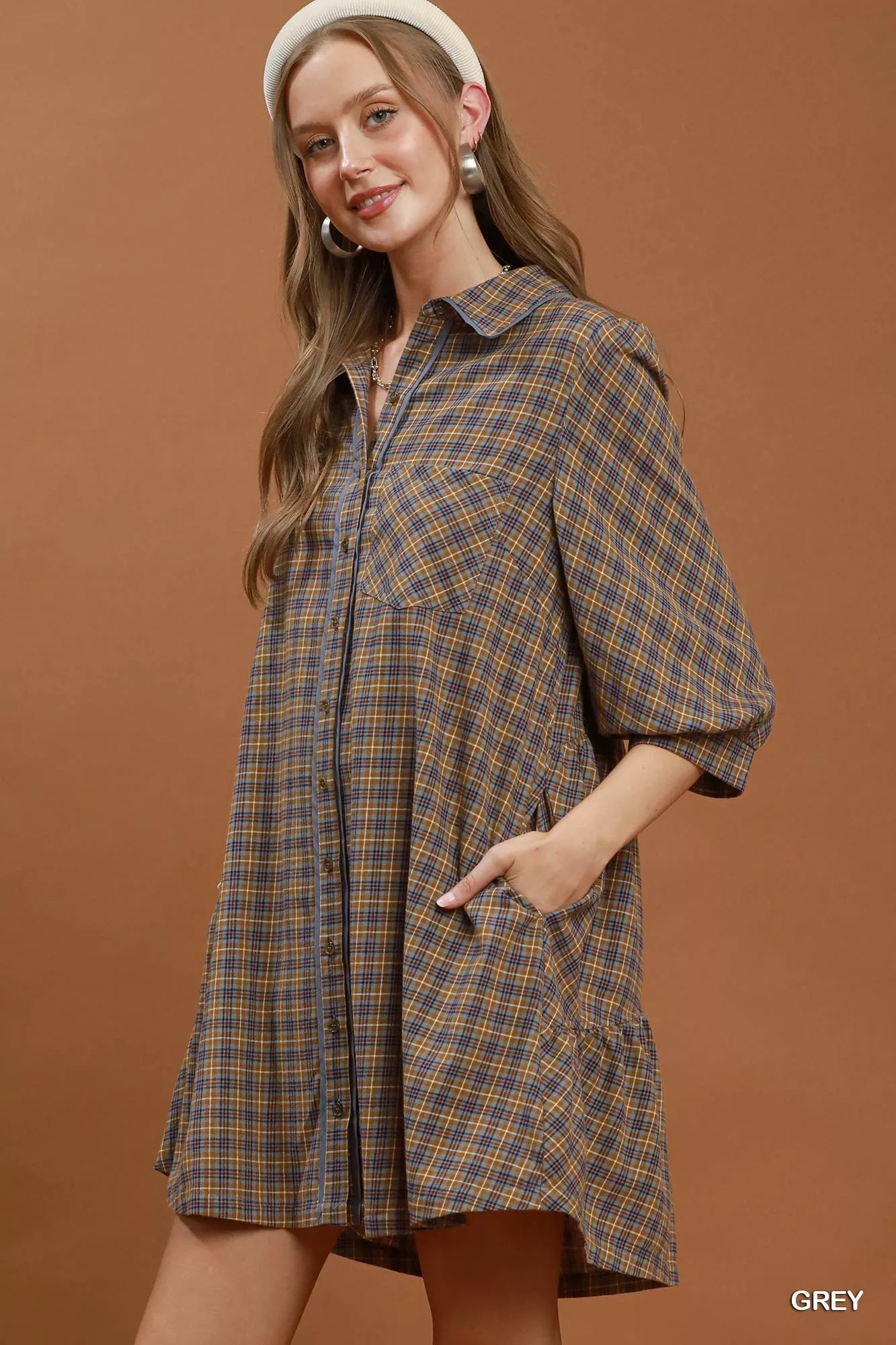 Oversized plaid button-down shirt dress with collared neckline, pocket detail, long sleeves, and relaxed cotton fit styled with a crossbody bag.