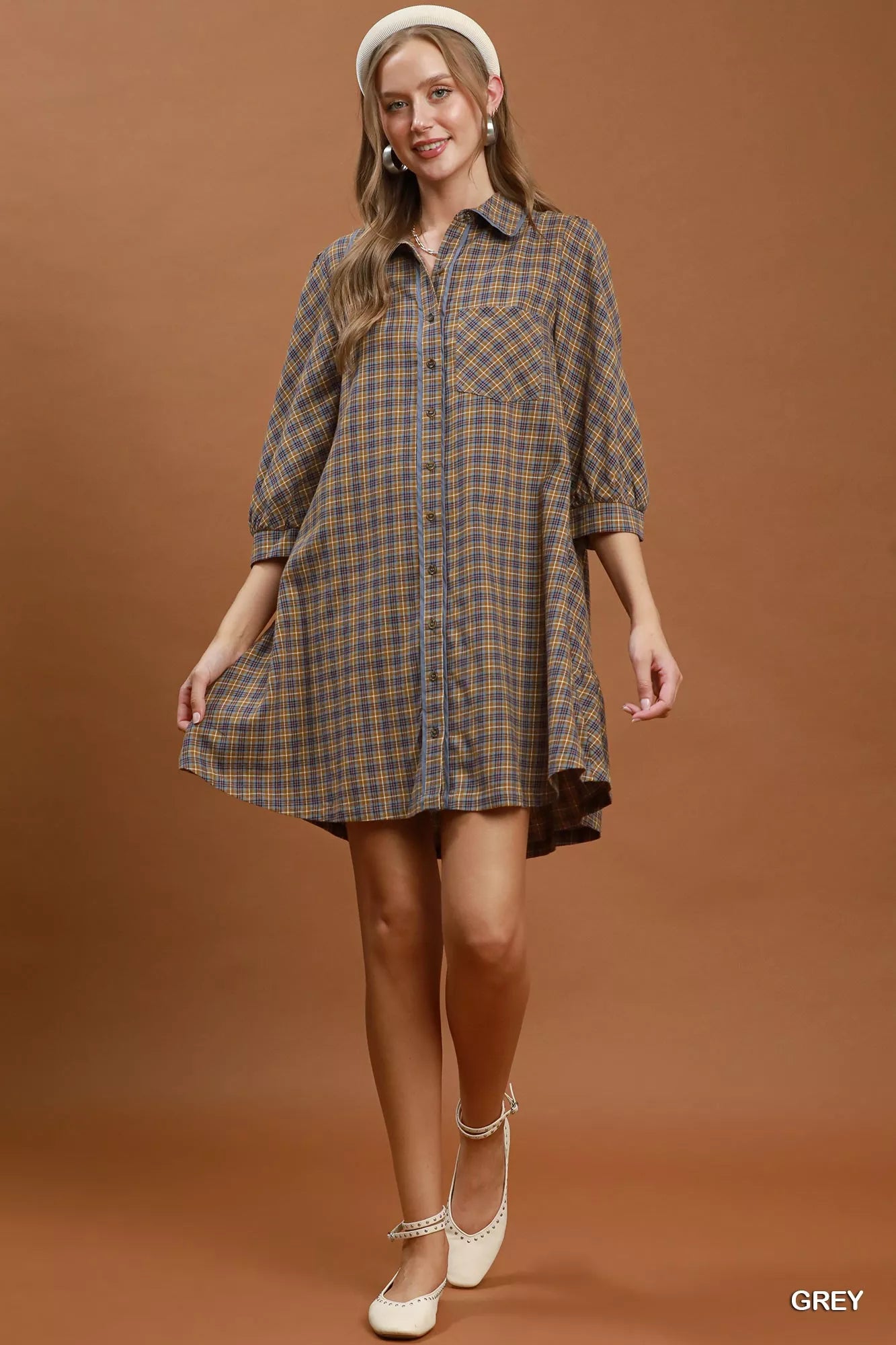 Oversized plaid button-down shirt dress with collared neckline, pocket detail, long sleeves, and relaxed cotton fit styled with a crossbody bag.