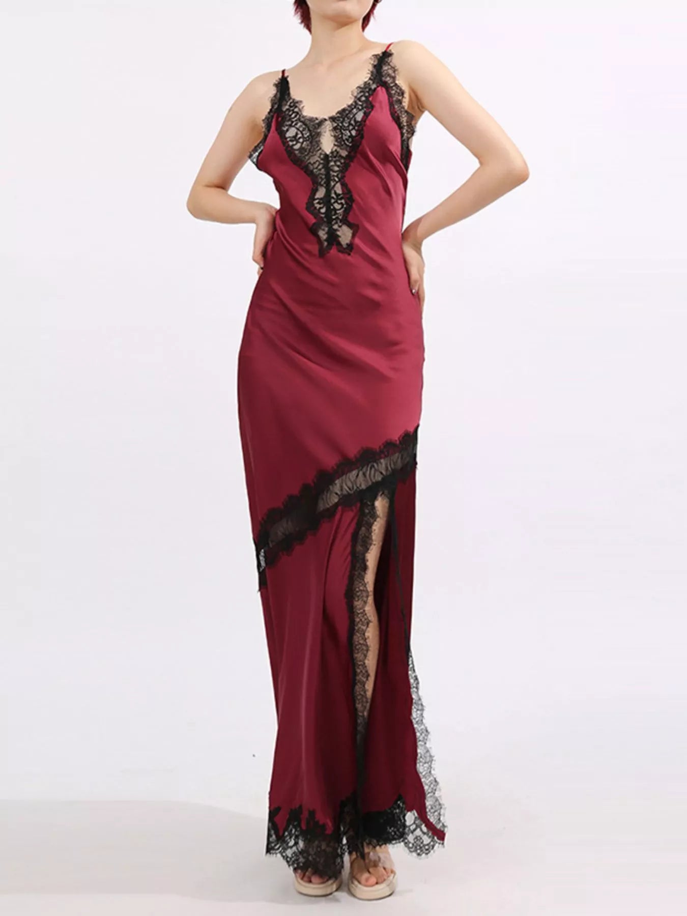 Crimson satin gown with black lace trim, deep V neckline, and thigh-high slit.