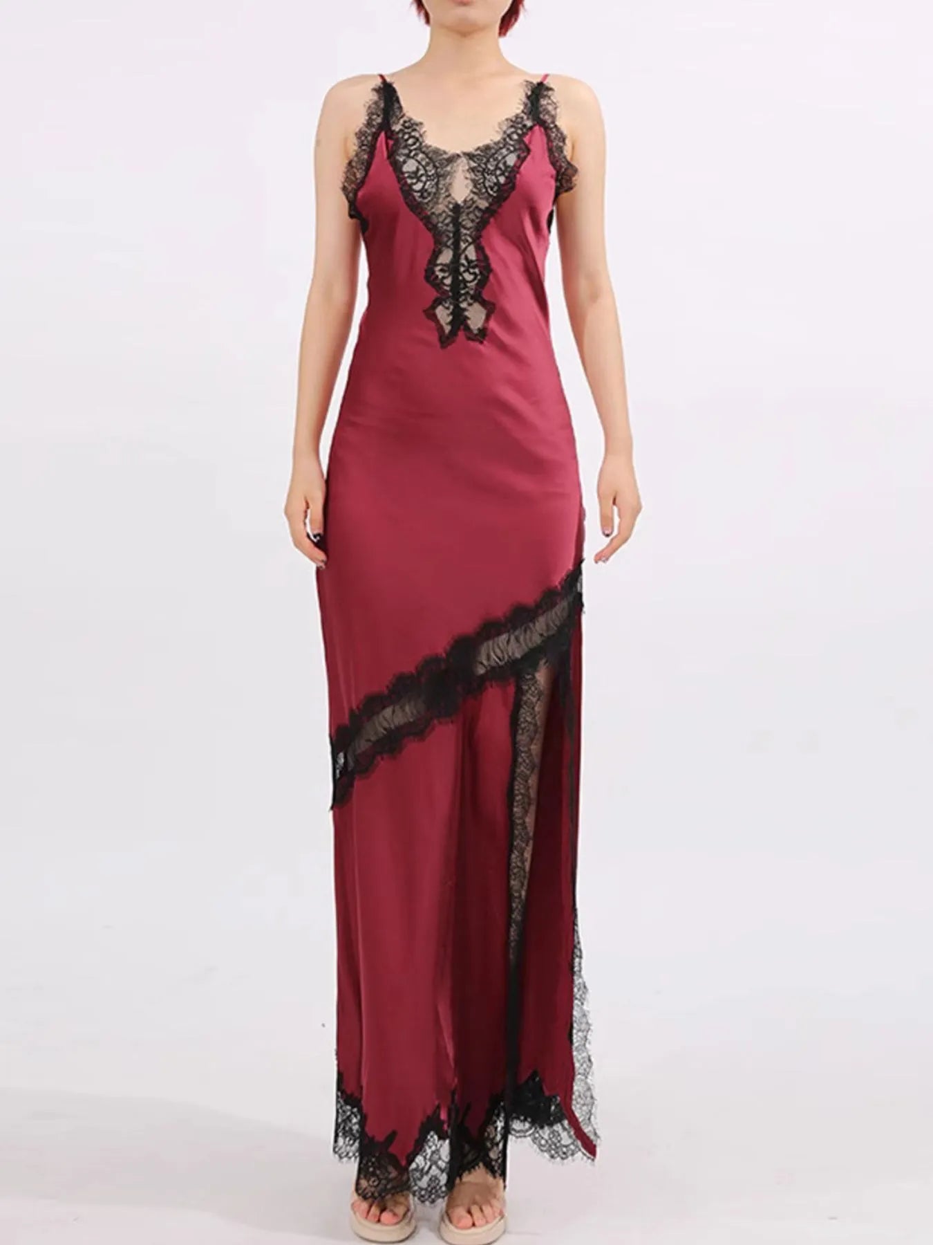 Crimson satin gown with black lace trim, deep V neckline, and thigh-high slit.
