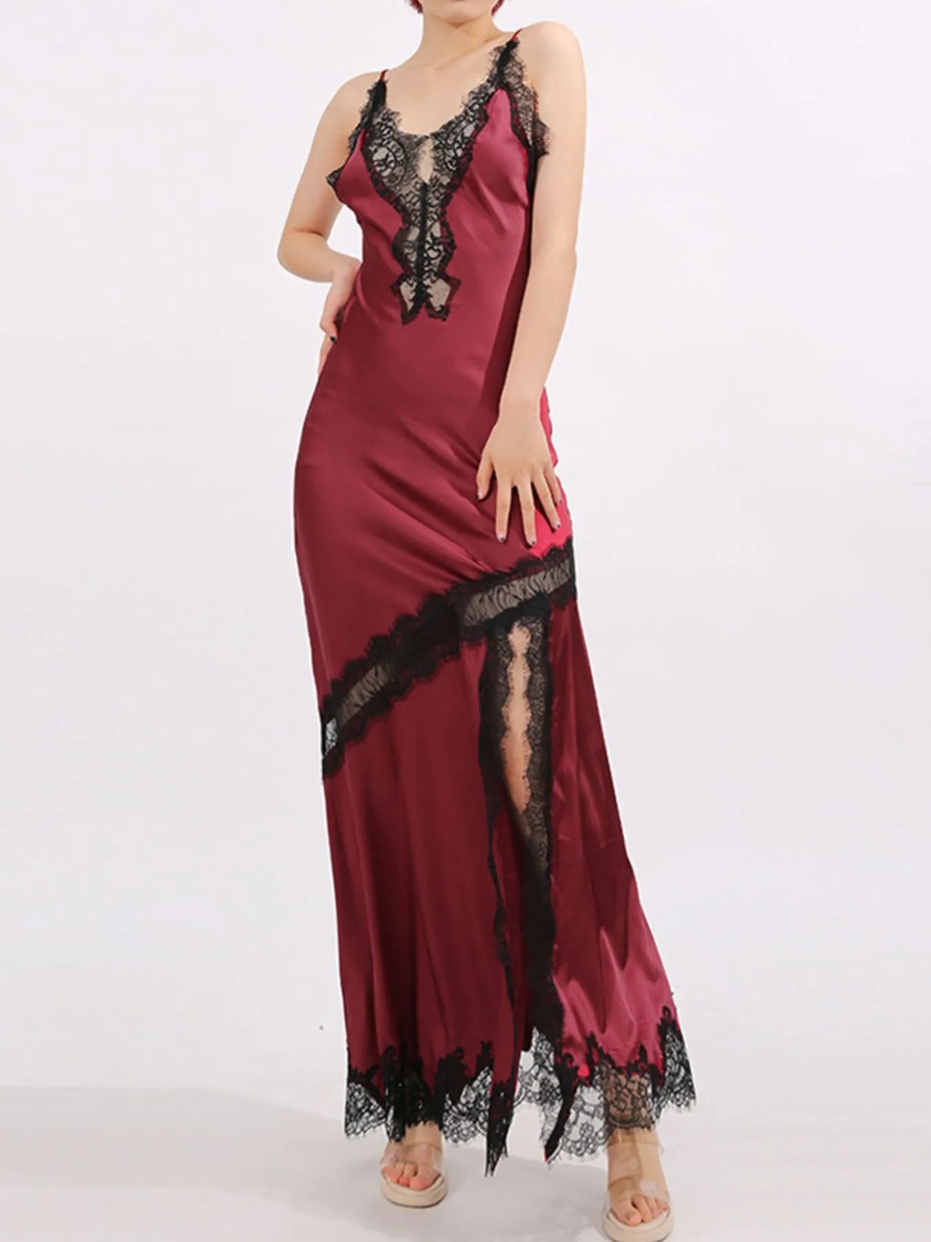 Crimson satin gown with black lace trim, deep V neckline, and thigh-high slit.