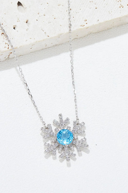 Sterling silver snowflake pendant necklace with a topaz center stone.