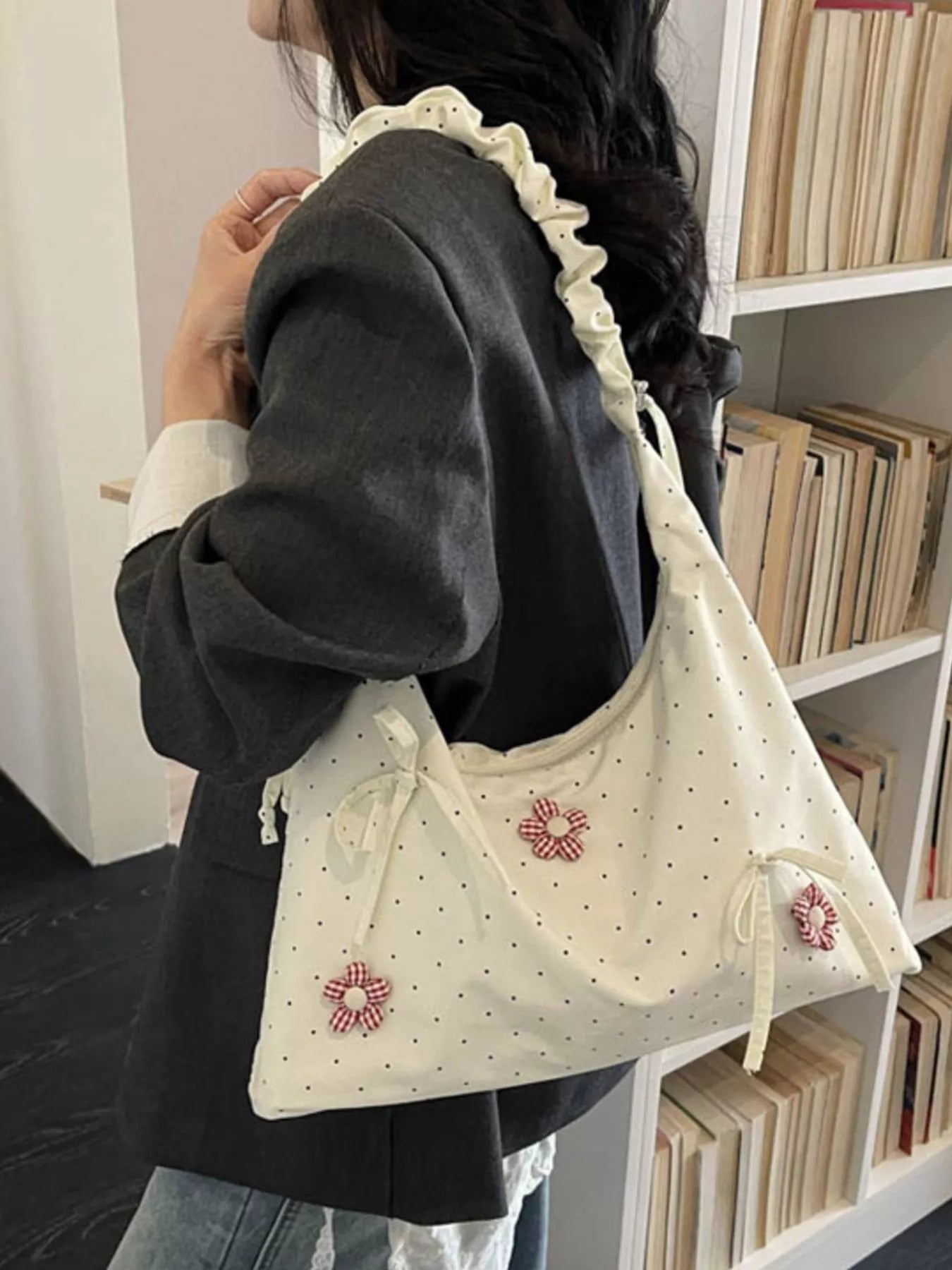 Medium shoulder bag with daisy floral appliqués, bow details, dotted fabric, ruffled strap, and soft cottagecore styling.