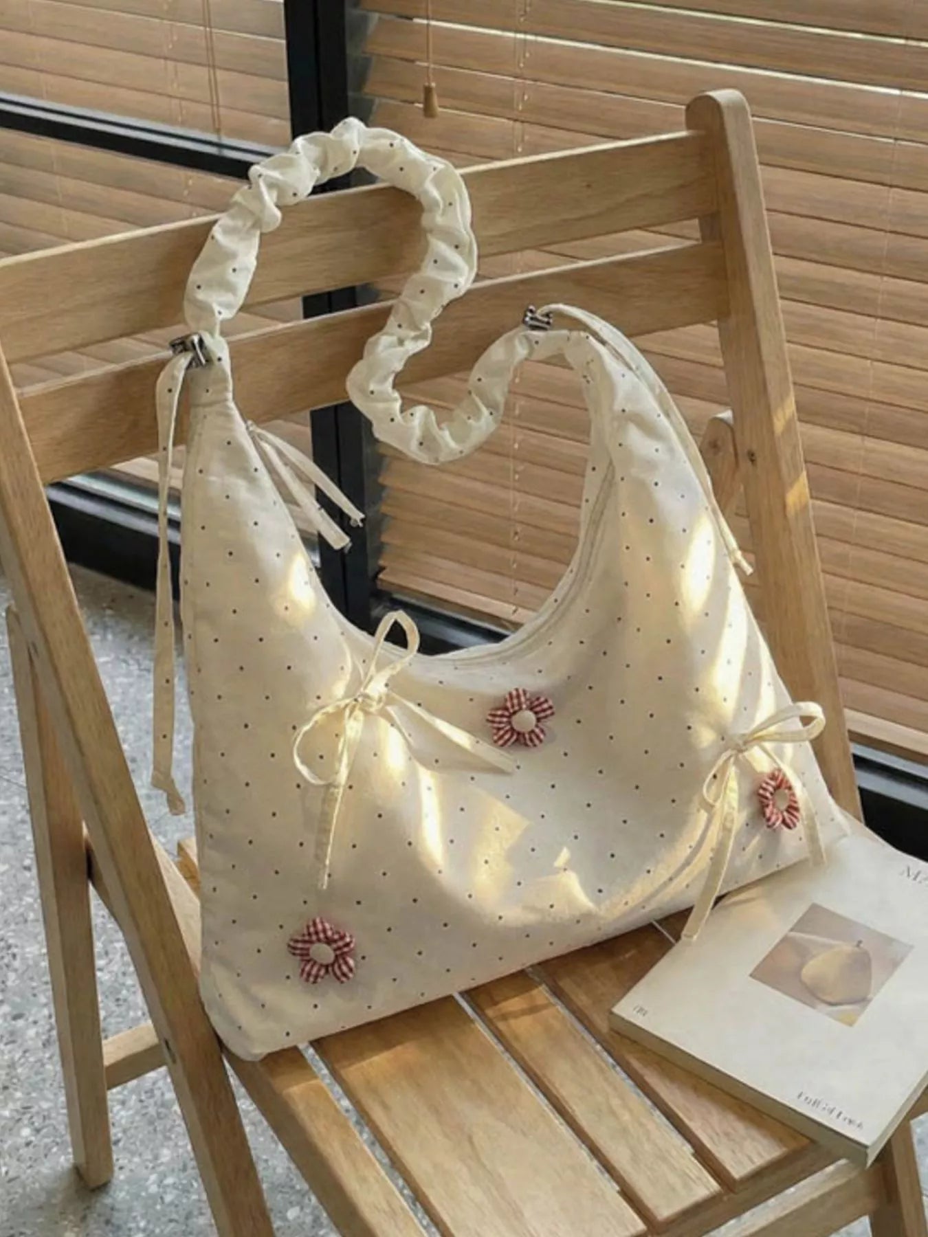Medium shoulder bag with daisy floral appliqués, bow details, dotted fabric, ruffled strap, and soft cottagecore styling.