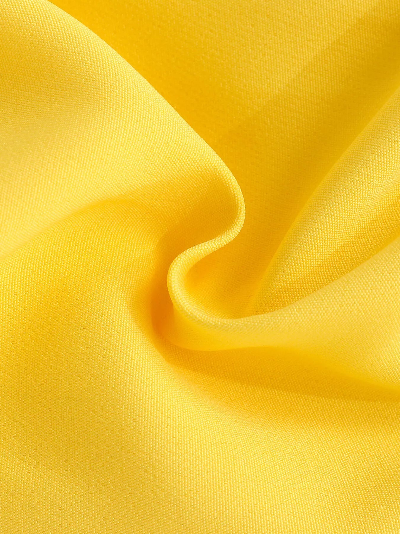 Yellow toddler romper with smocked bodice, daisy appliqué details, ruffled sleeves, pockets, and soft cotton-blend fabric.