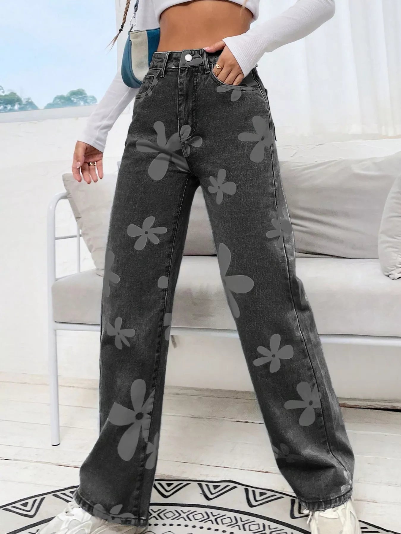 Wide-leg jeans with oversized daisy print, pocketed design, high-rise fit, and relaxed statement denim style.