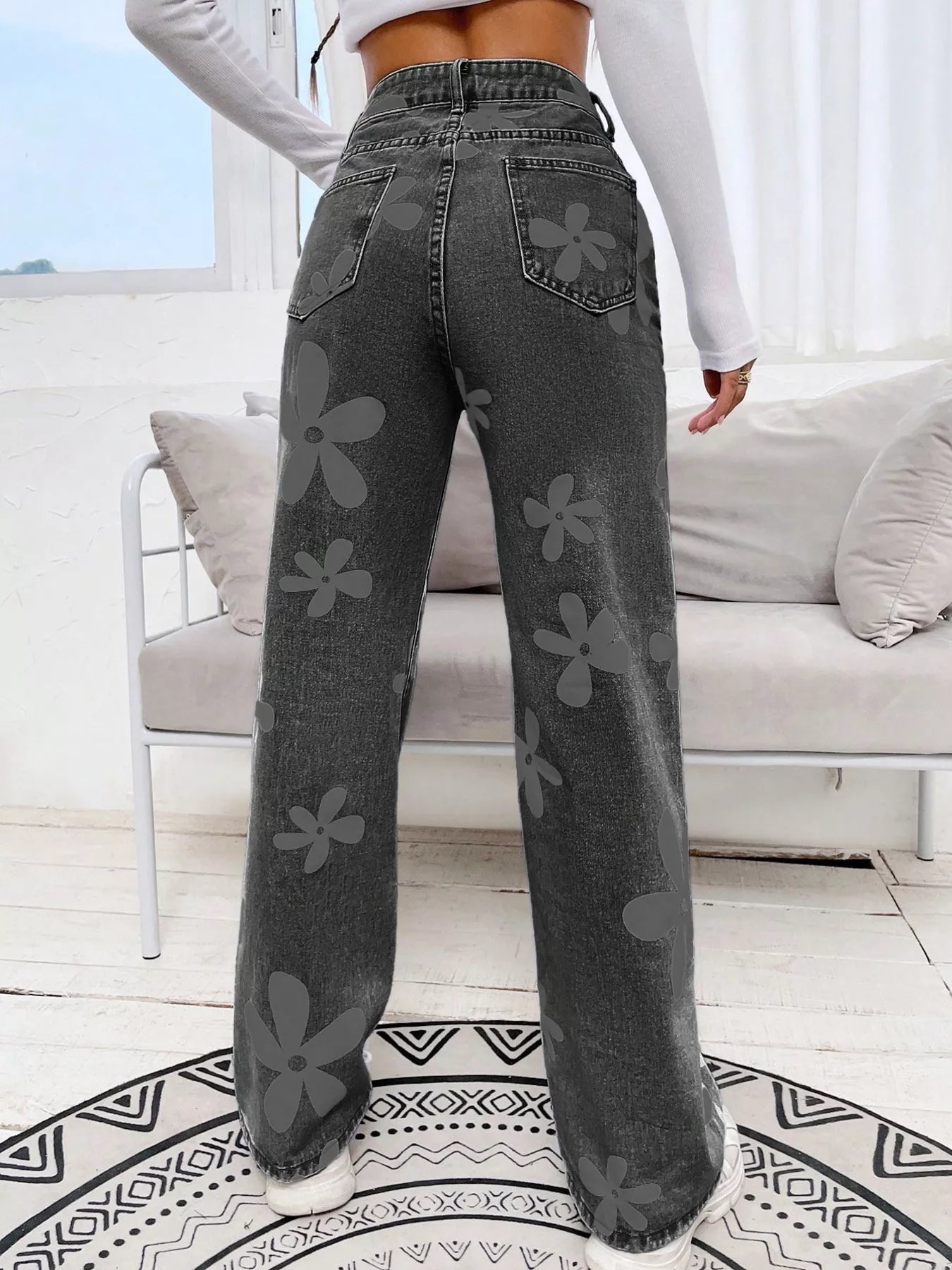 Wide-leg jeans with oversized daisy print, pocketed design, high-rise fit, and relaxed statement denim style.