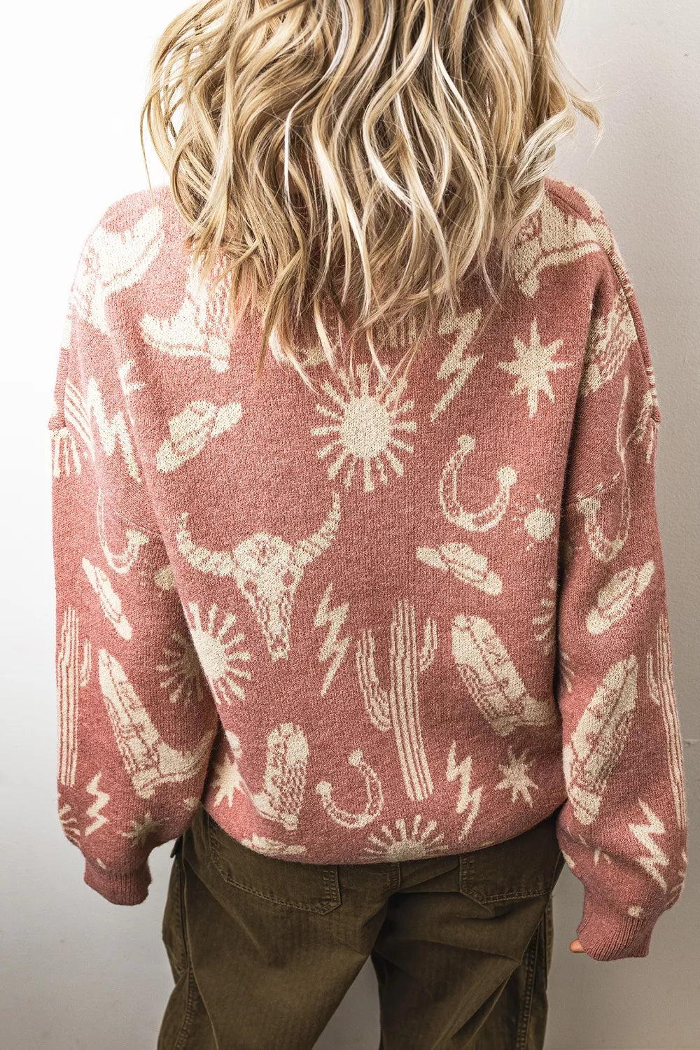 Boho western knit sweater with desert motifs, ribbed neckline and cuffs, relaxed long sleeves, and slightly stretchy acrylic-blend fabric.