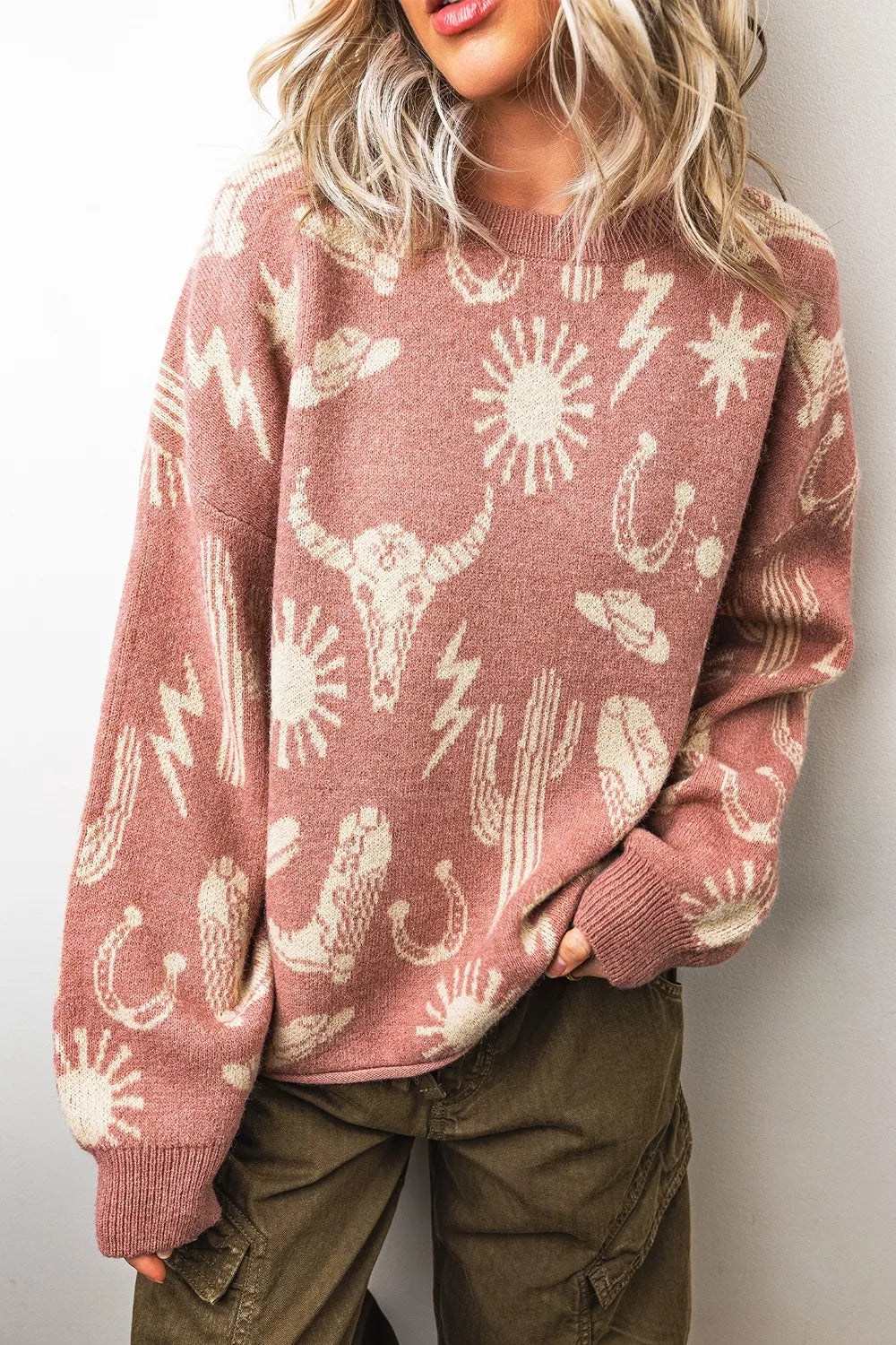 Boho western knit sweater with desert motifs, ribbed neckline and cuffs, relaxed long sleeves, and slightly stretchy acrylic-blend fabric.