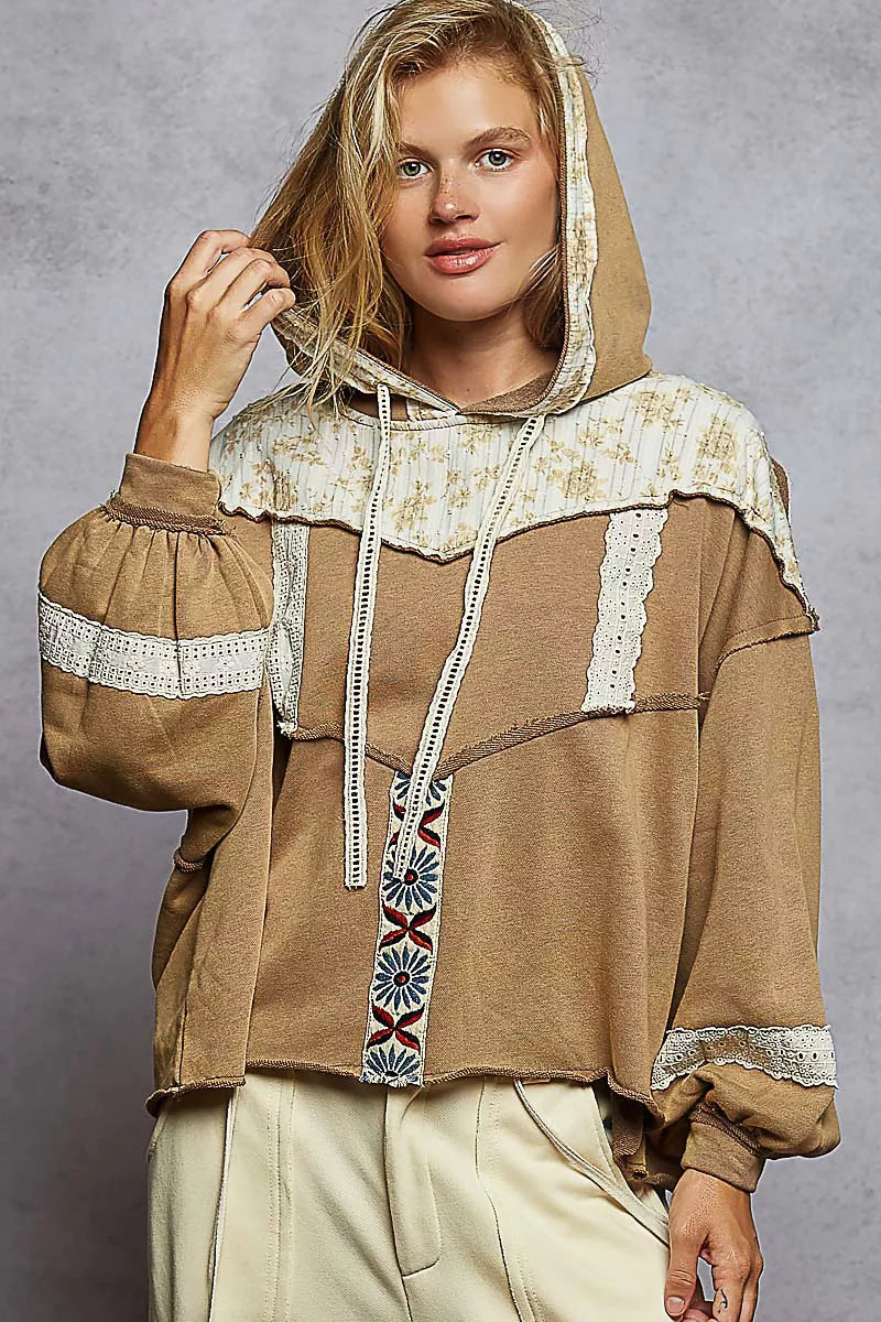 Vintage-washed tan hoodie with patchwork floral accents, lace trim, and balloon sleeves.