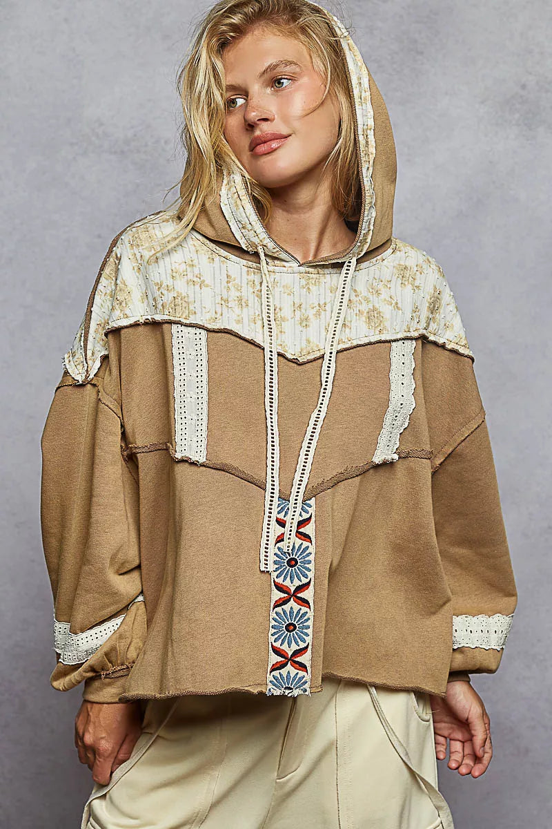 Vintage-washed tan hoodie with patchwork floral accents, lace trim, and balloon sleeves.
