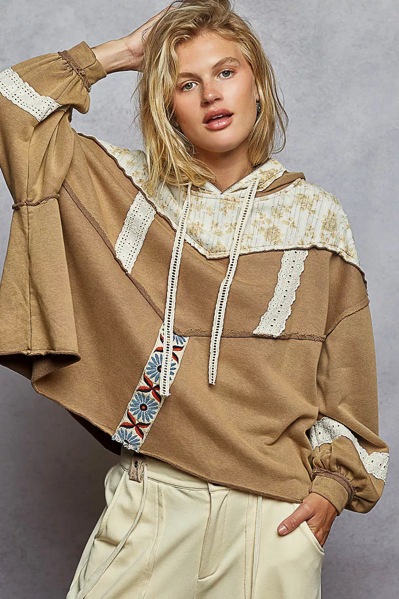 Vintage-washed tan hoodie with patchwork floral accents, lace trim, and balloon sleeves.