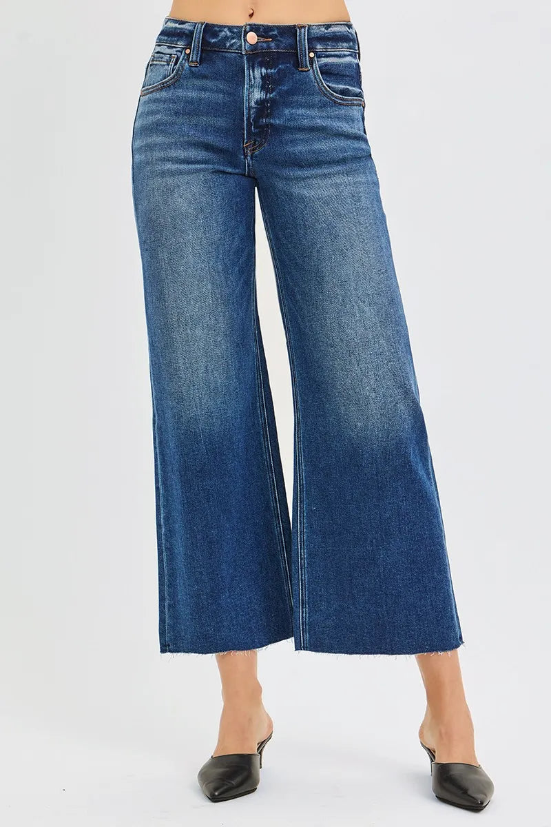 Woman wearing Driftwood Raw Hem Jeans with wide leg cropped fit and raw cut hem.