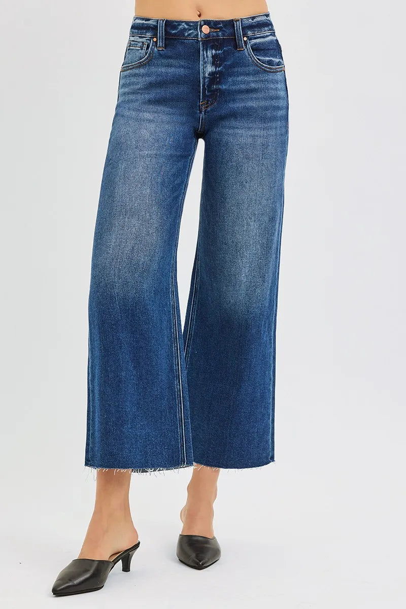 Woman wearing Driftwood Raw Hem Jeans with wide leg cropped fit and raw cut hem.