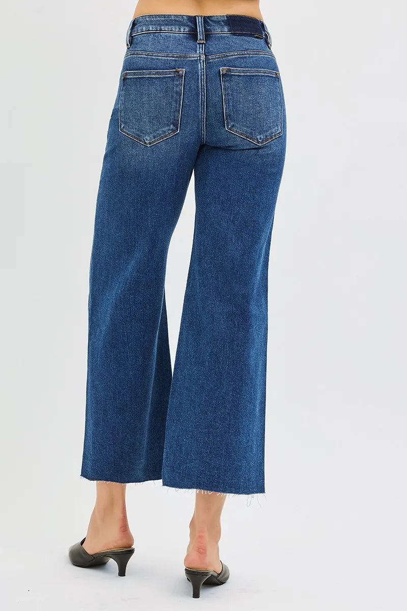 Woman wearing Driftwood Raw Hem Jeans with wide leg cropped fit and raw cut hem.