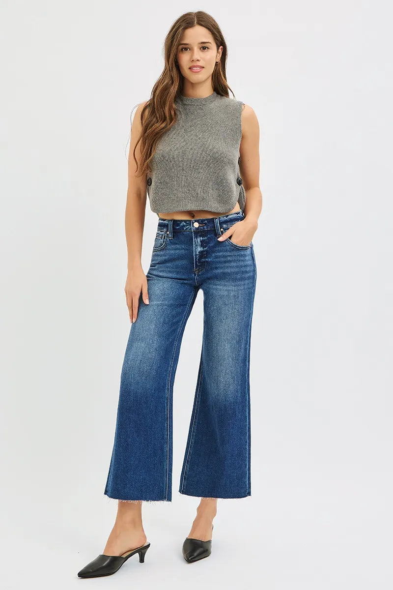 Woman wearing Driftwood Raw Hem Jeans with wide leg cropped fit and raw cut hem.