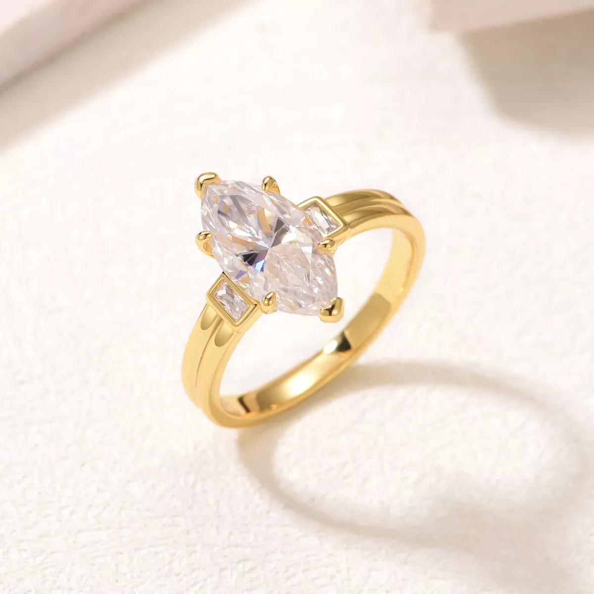Close-up of a marquise-cut moissanite ring with 18K gold-plated band and zircon accents – elegant fine jewelry from A Whimsical Affair.