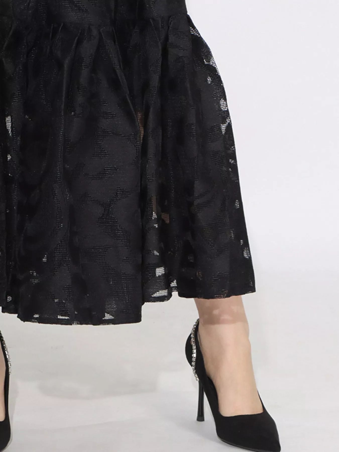 Model wearing the Ethereal Grace Lace Maxi Dress in black, with puff sleeves, button-down front, tie waist, and sheer lace fabric for an elegant look.