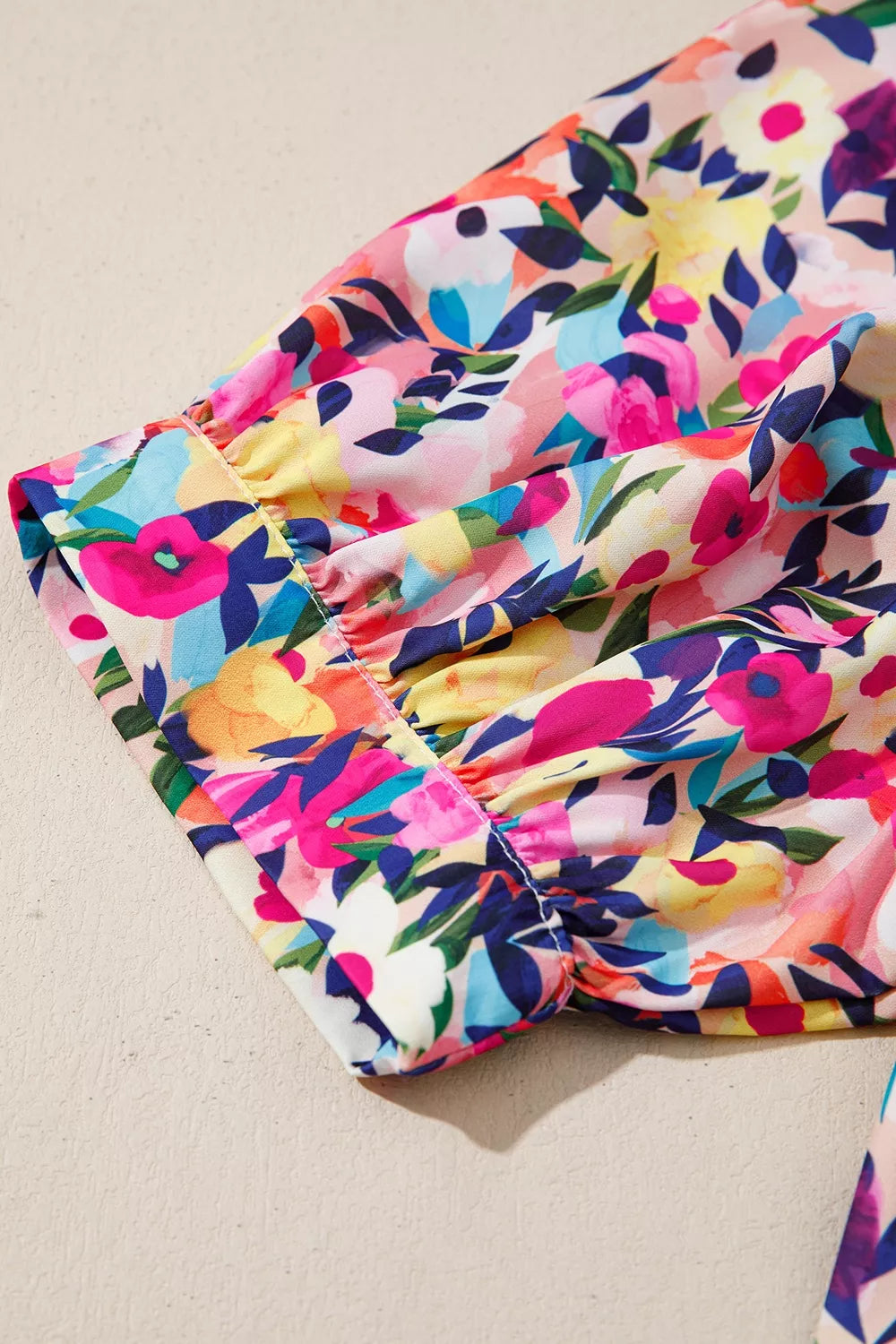 Colorful floral blouse with frill neckline detail, puff-style short sleeves, relaxed fit, and slightly stretchy fabric styled with denim shorts.