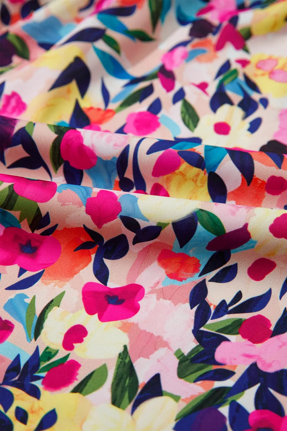 Colorful floral blouse with frill neckline detail, puff-style short sleeves, relaxed fit, and slightly stretchy fabric styled with denim shorts.