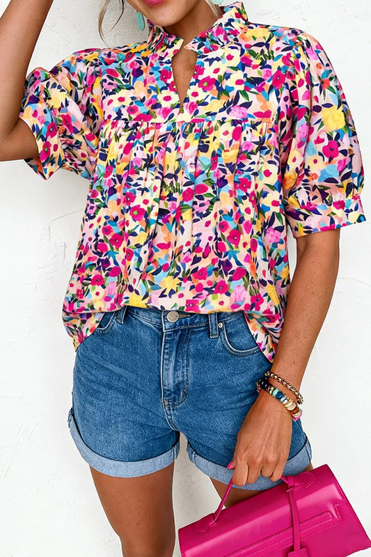Colorful floral blouse with frill neckline detail, puff-style short sleeves, relaxed fit, and slightly stretchy fabric styled with denim shorts.