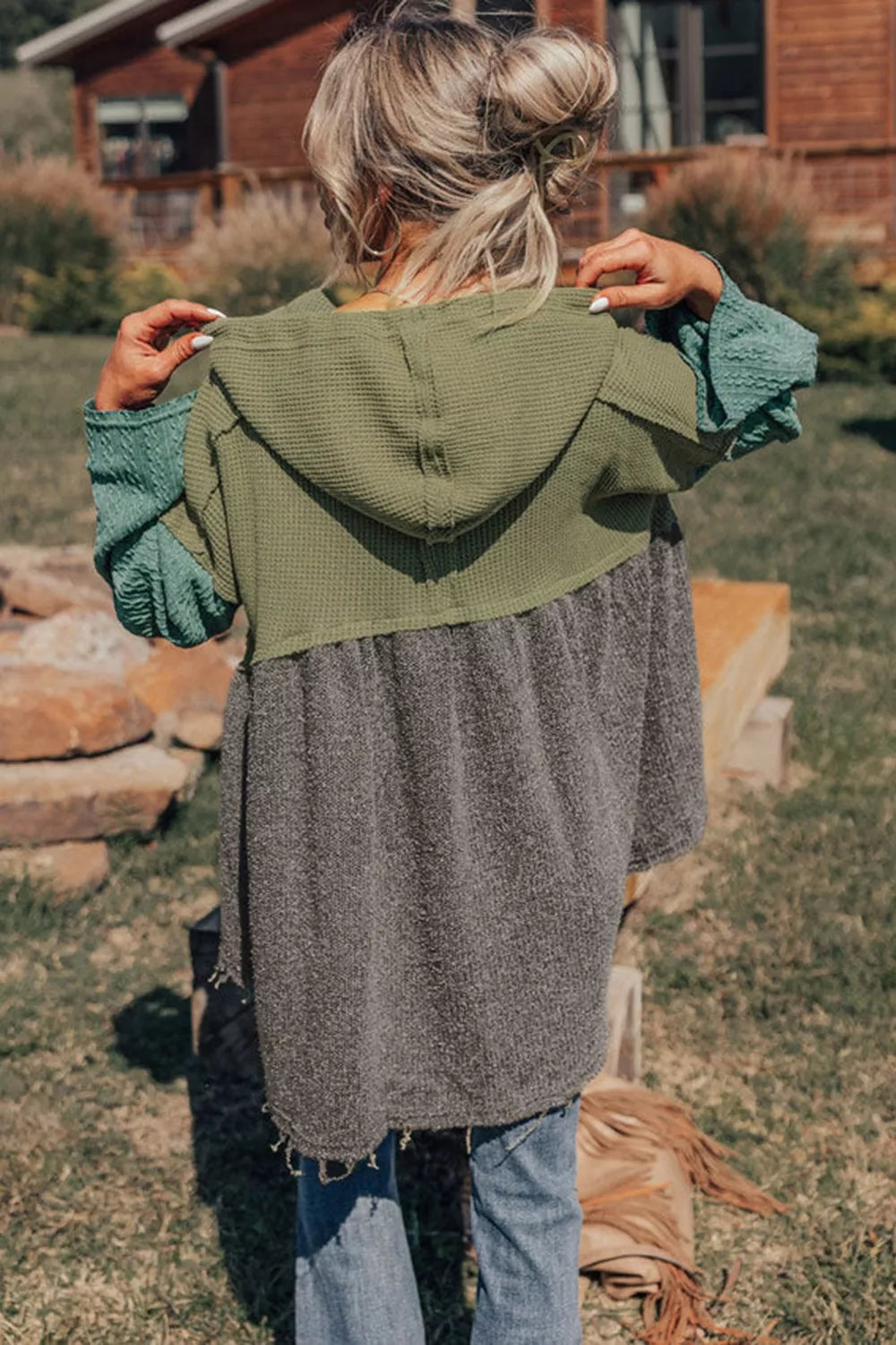 Woman wearing a colorblock drawstring hoodie with distressed jeans outdoors
