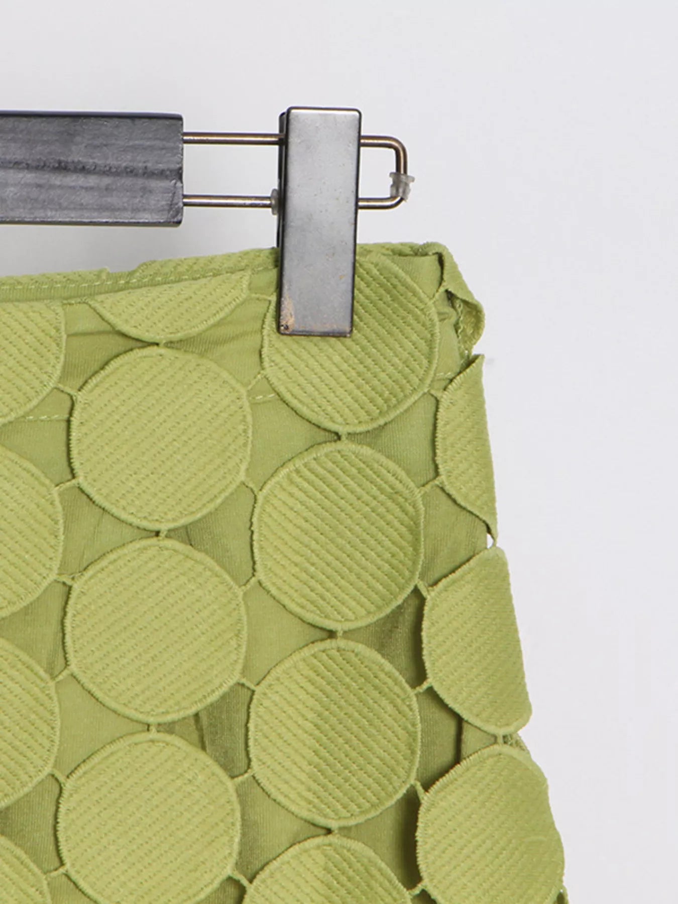 Green fringe midi skirt with cutout circles and flowing fringe detail