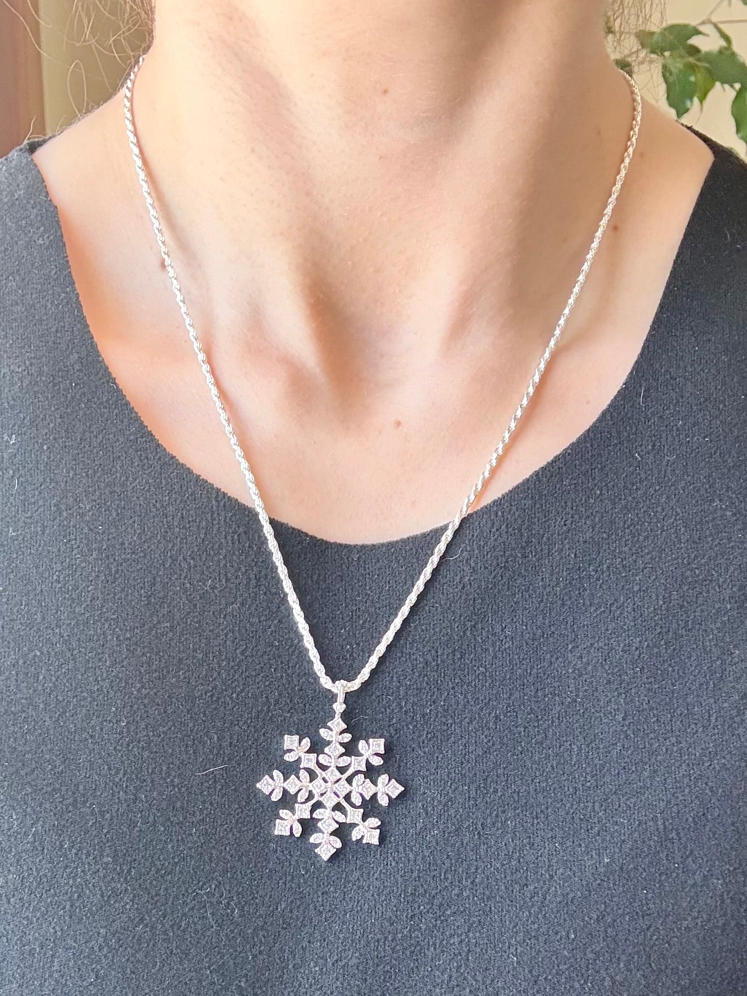Sterling silver snowflake pendant necklace from the Enchanted Crystals Collection, worn on a matching silver chain.