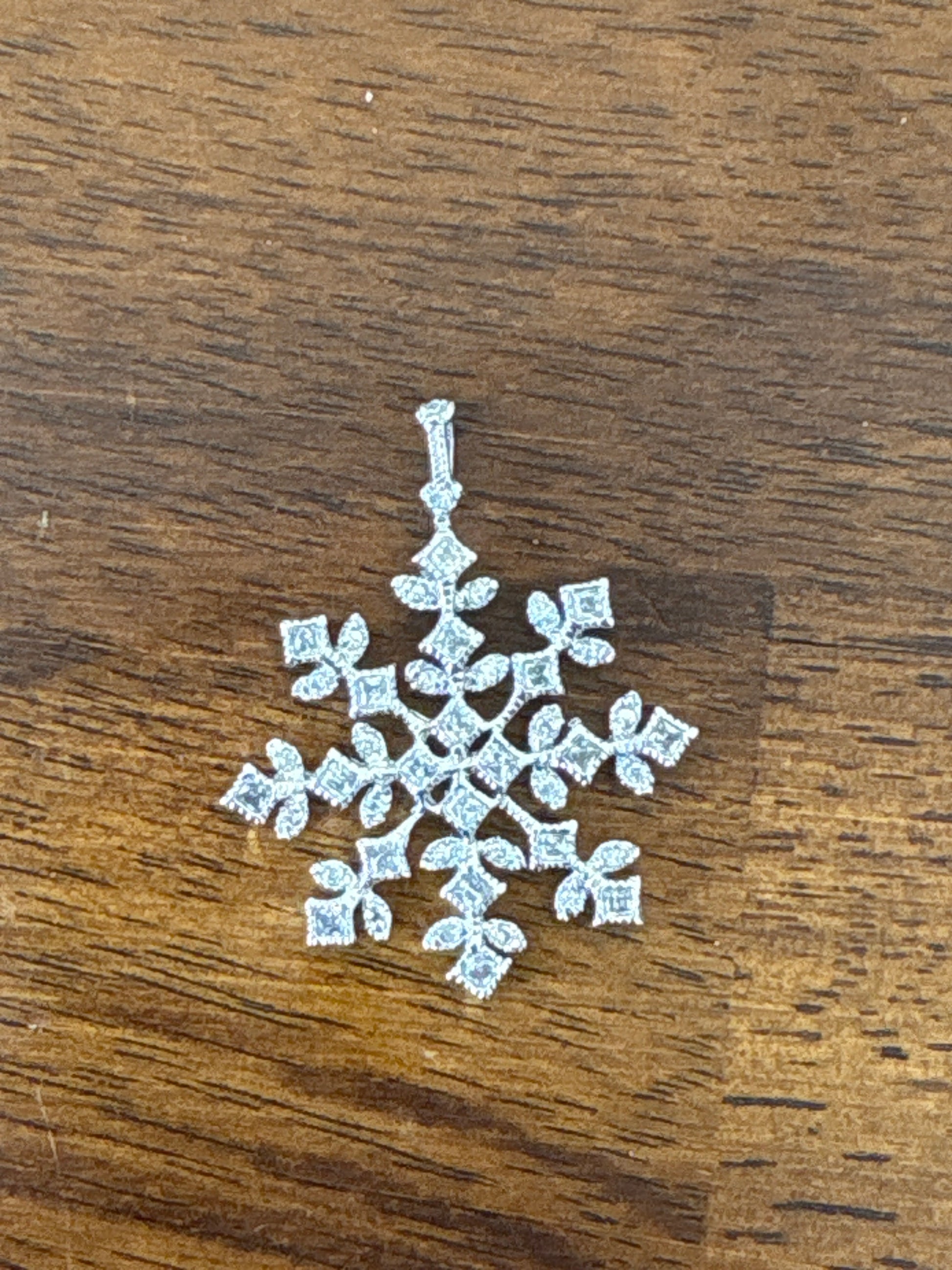 Sterling silver snowflake pendant necklace from the Enchanted Crystals Collection, worn on a matching silver chain.