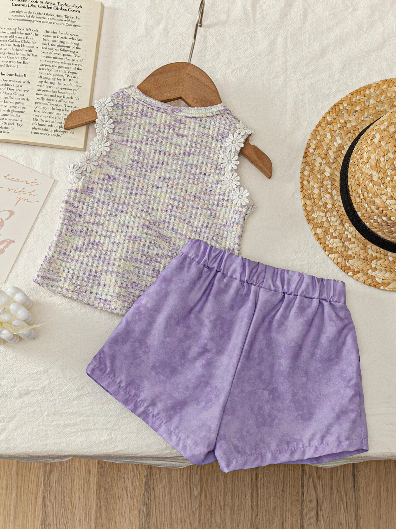 Two-piece baby outfit with textured appliqué sleeveless top, daisy trim neckline, and lavender flowy shorts.