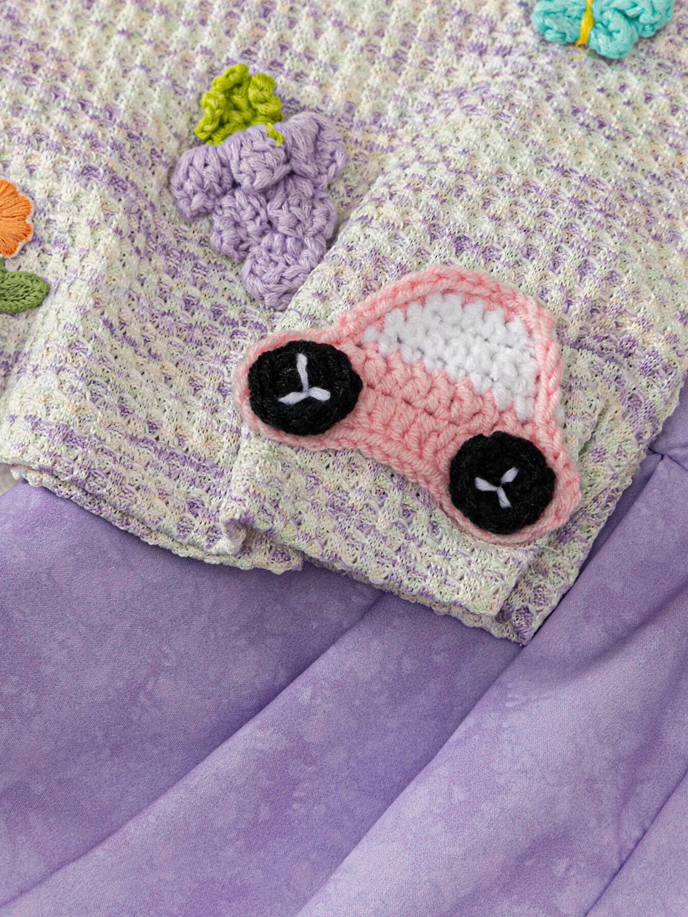 Two-piece baby outfit with textured appliqué sleeveless top, daisy trim neckline, and lavender flowy shorts.