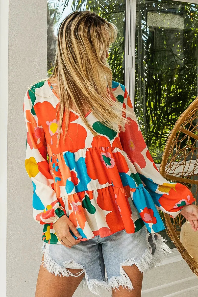 Garden Muse Ruffle Blouse by BiBi – multicolor floral print blouse with V-neckline, tiered ruffles, and elastic cuff sleeves.