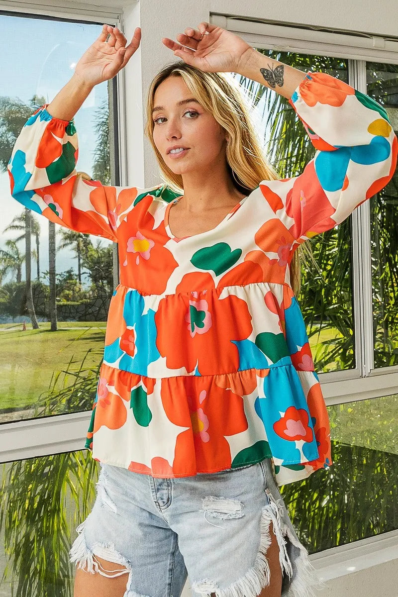 Garden Muse Ruffle Blouse by BiBi – multicolor floral print blouse with V-neckline, tiered ruffles, and elastic cuff sleeves.