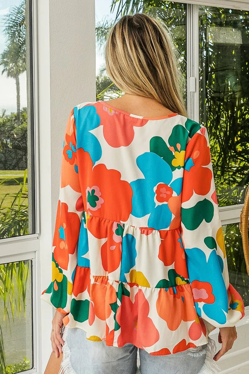 Garden Muse Ruffle Blouse by BiBi – multicolor floral print blouse with V-neckline, tiered ruffles, and elastic cuff sleeves.
