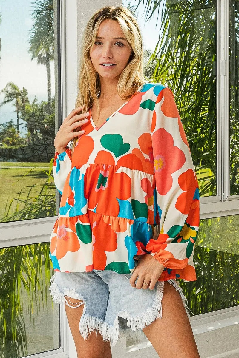 Garden Muse Ruffle Blouse by BiBi – multicolor floral print blouse with V-neckline, tiered ruffles, and elastic cuff sleeves.