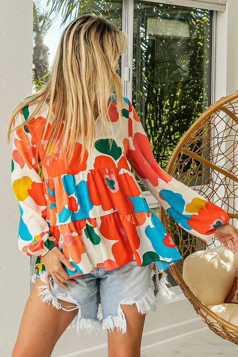 Garden Muse Ruffle Blouse by BiBi – multicolor floral print blouse with V-neckline, tiered ruffles, and elastic cuff sleeves.