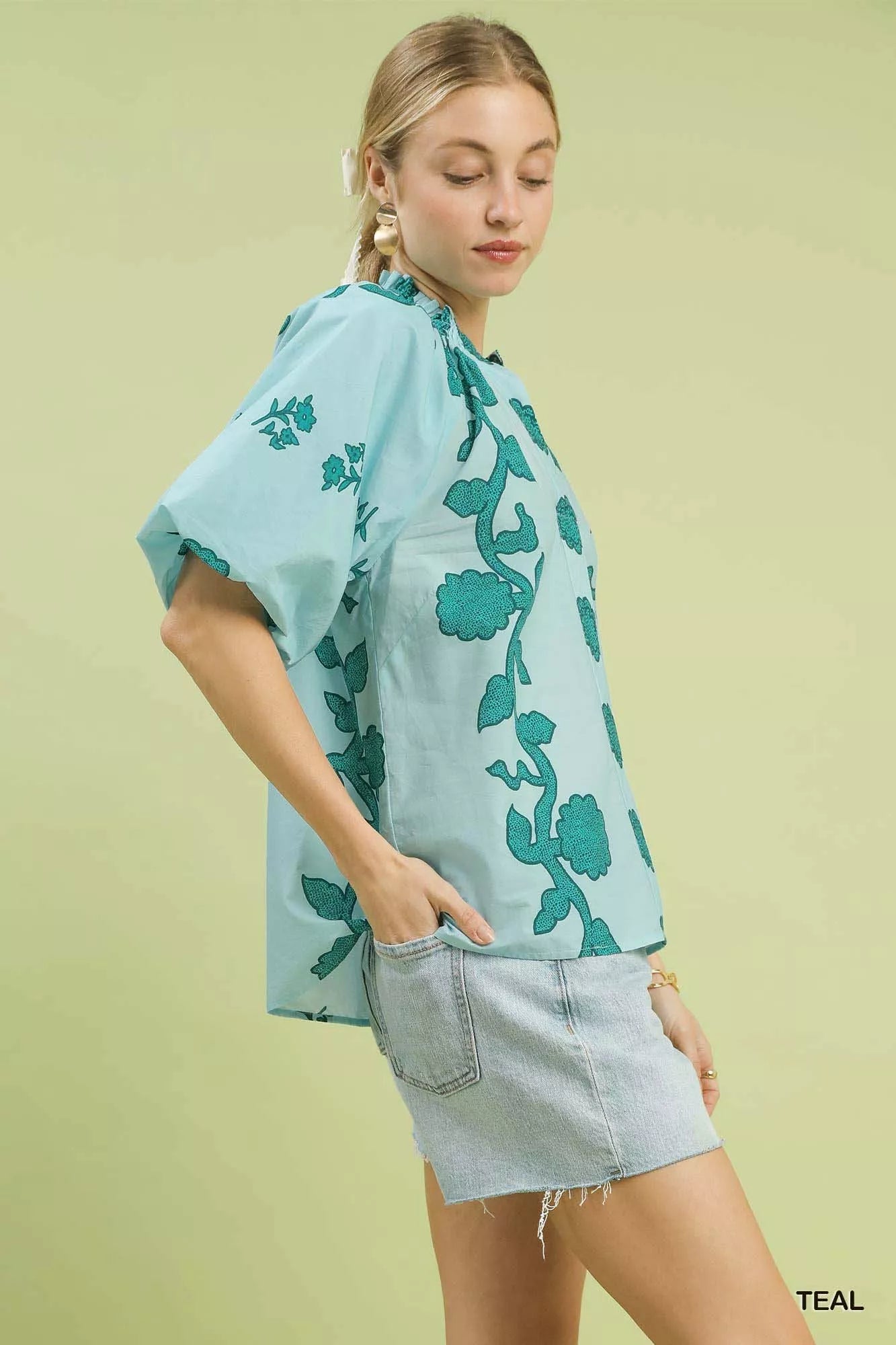Smocked collared cotton top with puff sleeves and a relaxed fit styled with denim shorts.