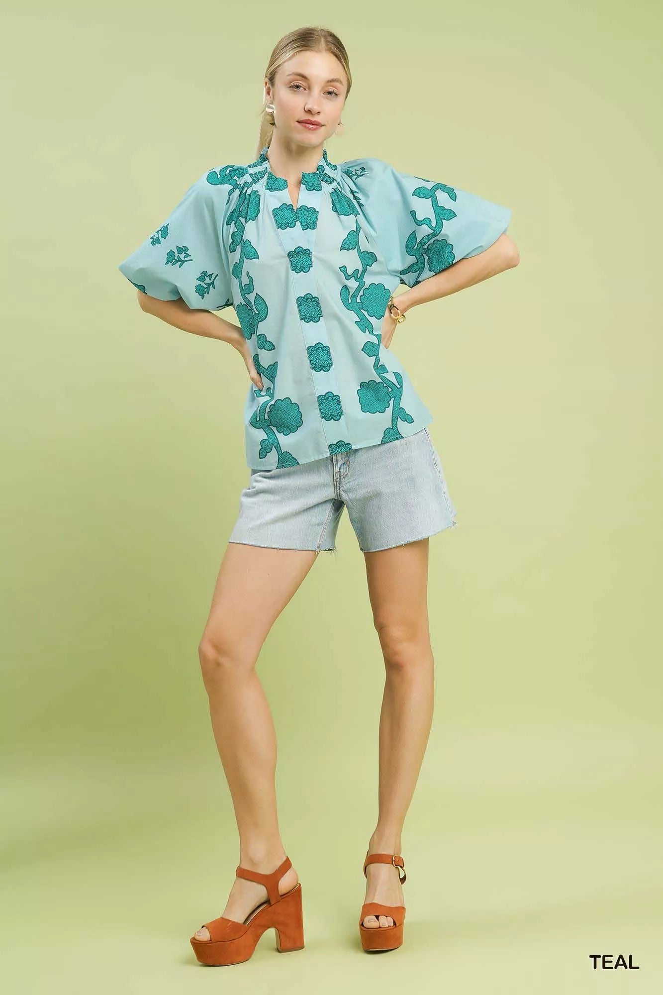 Smocked collared cotton top with puff sleeves and a relaxed fit styled with denim shorts.