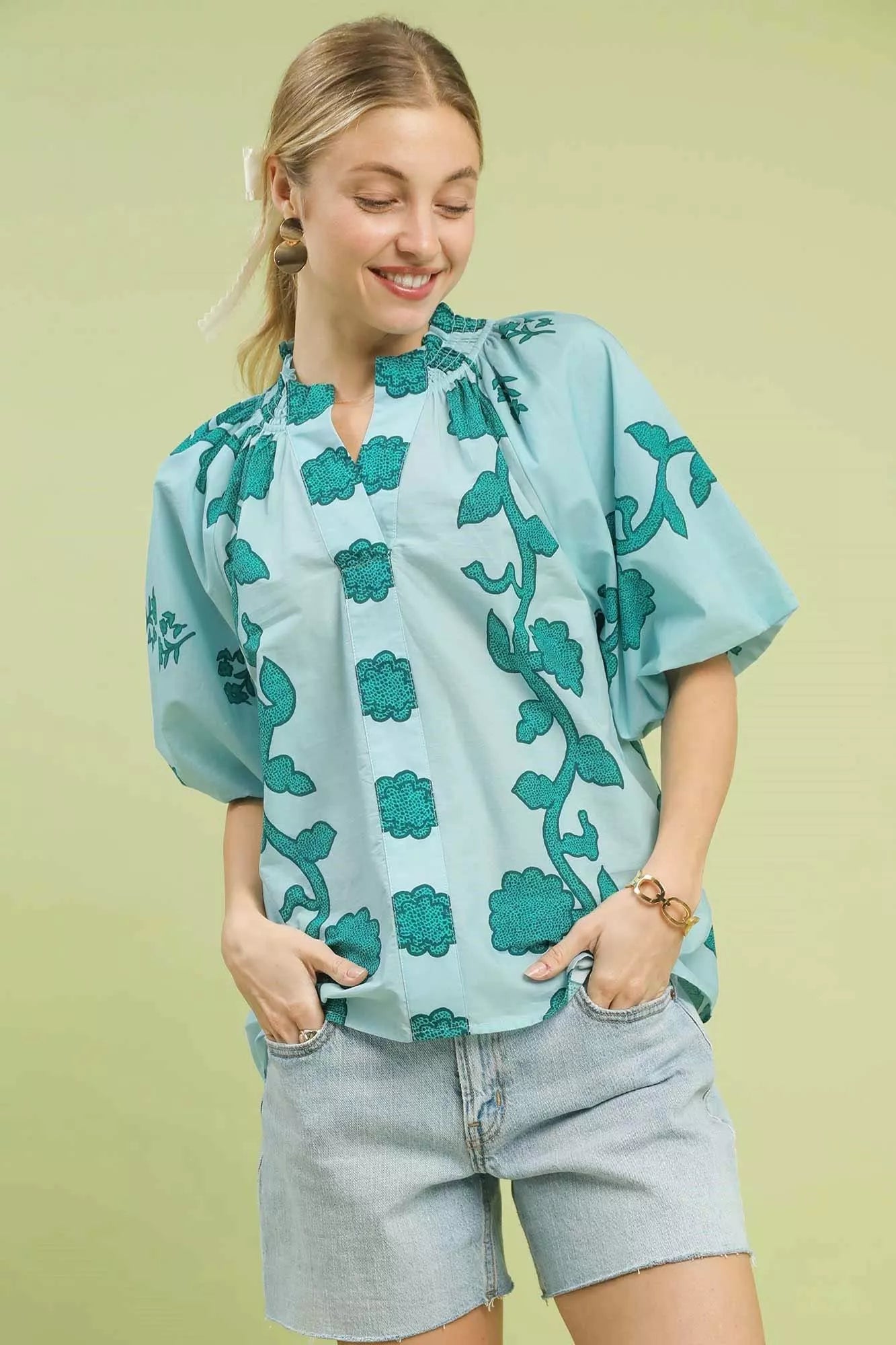 Smocked collared cotton top with puff sleeves and a relaxed fit styled with denim shorts.