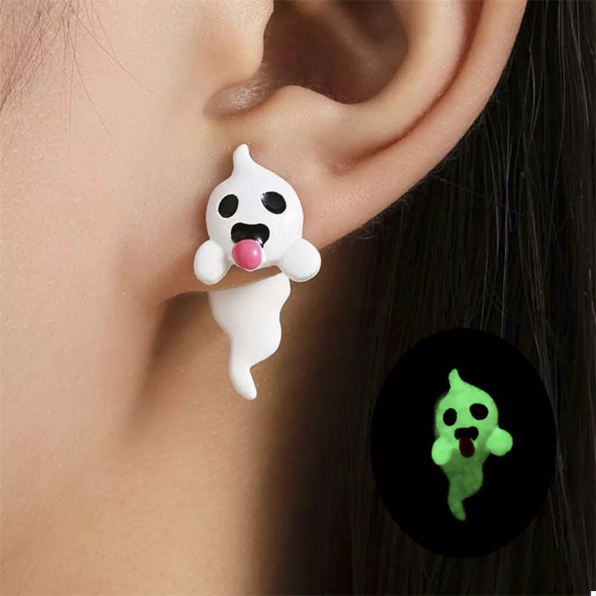 Close-up of a woman wearing glow-in-the-dark ghost earrings featuring white resin ghosts with pink tongues — spooky cute Halloween jewelry from A Whimsical Affair.