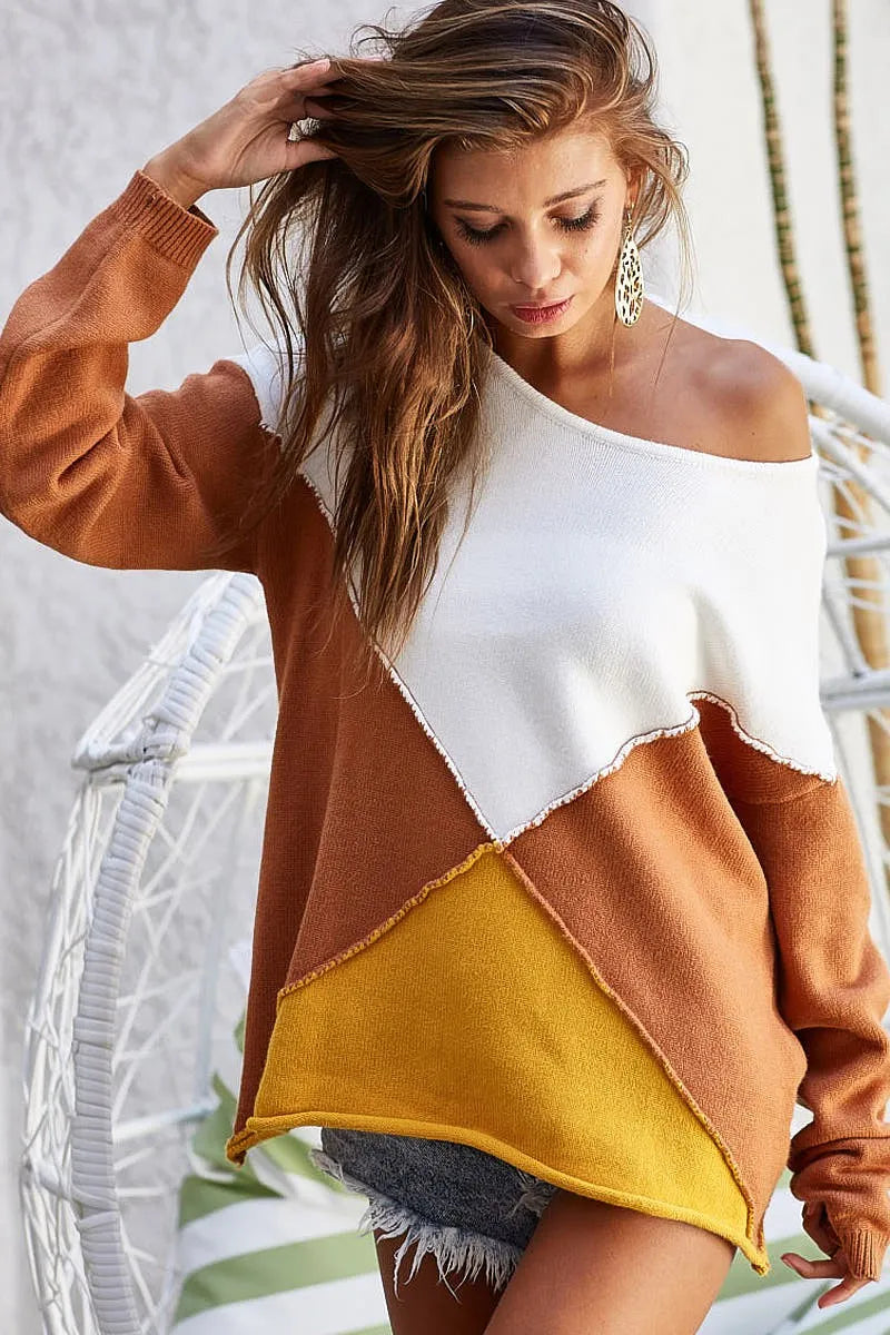 Woman wearing Golden Horizon Colorblock Sweater with oversized fit and geometric design in white, mustard, and rust tones.