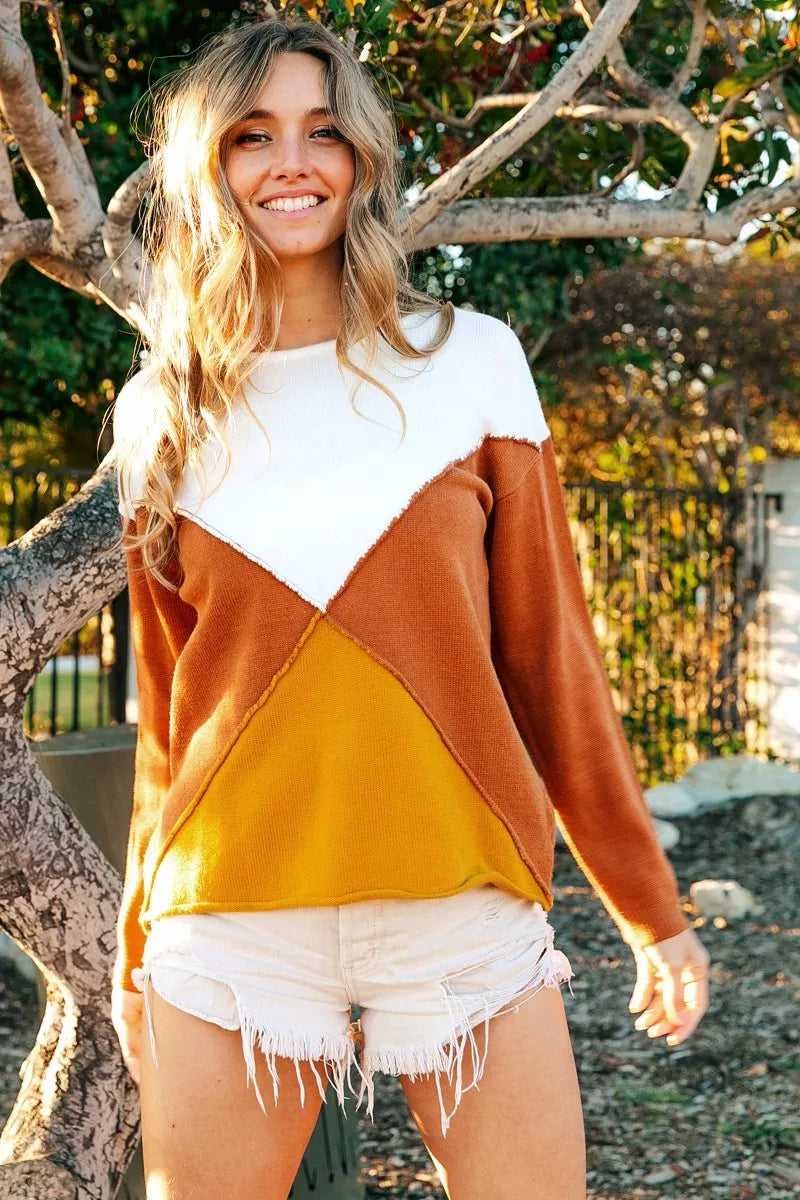 Woman wearing Golden Horizon Color Block Sweater with oversized fit and geometric design in white, mustard, and rust tones.