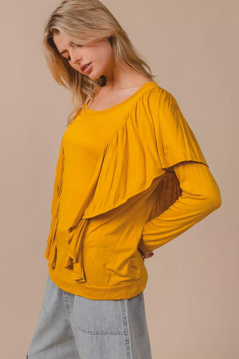Golden yellow long sleeve top with cascade ruffle overlay, ruched details, round neckline, and slightly stretchy rayon fabric.