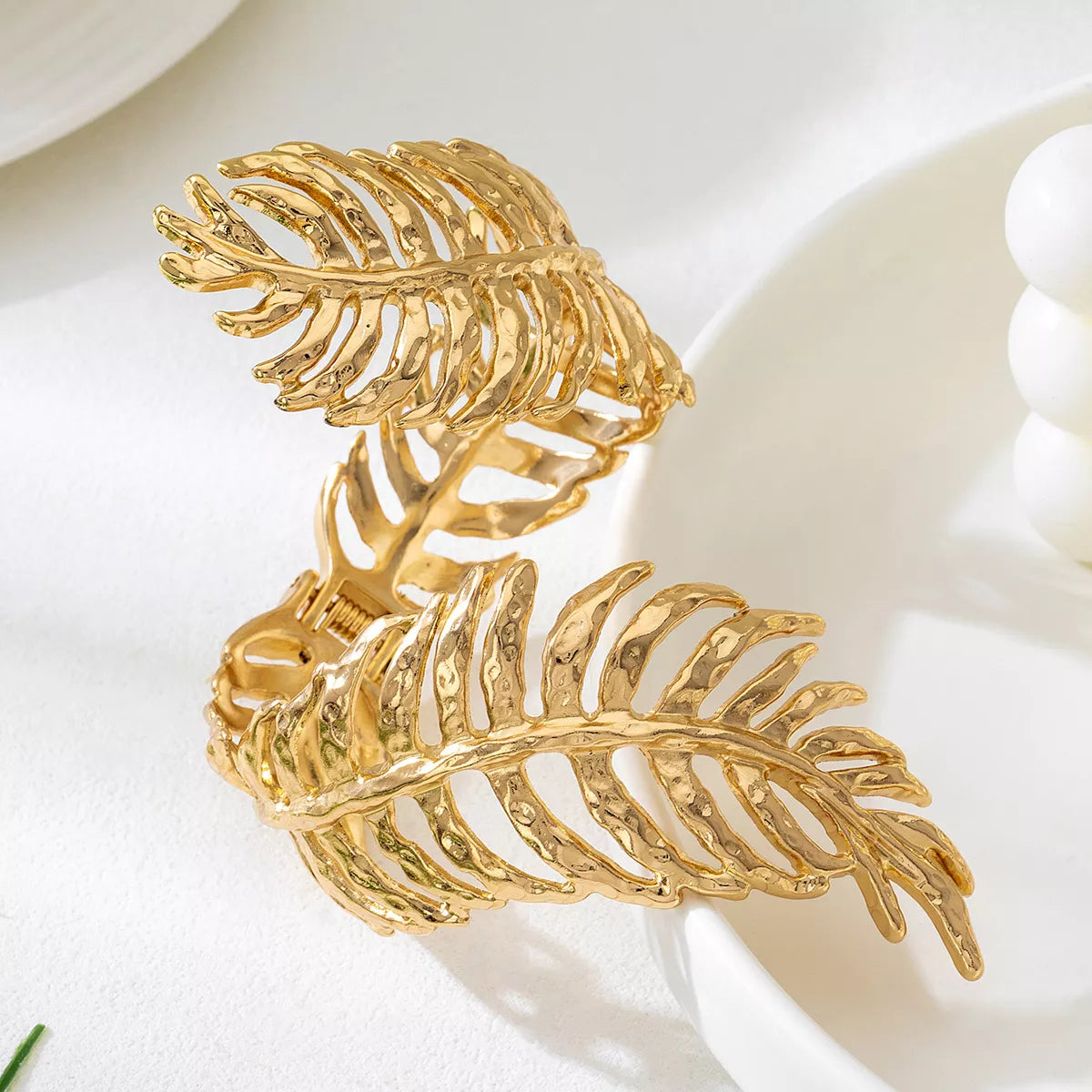18K gold-plated palm leaf cuff bracelet with hammered texture, worn on wrist — elegant boho statement jewelry from A Whimsical Affair.