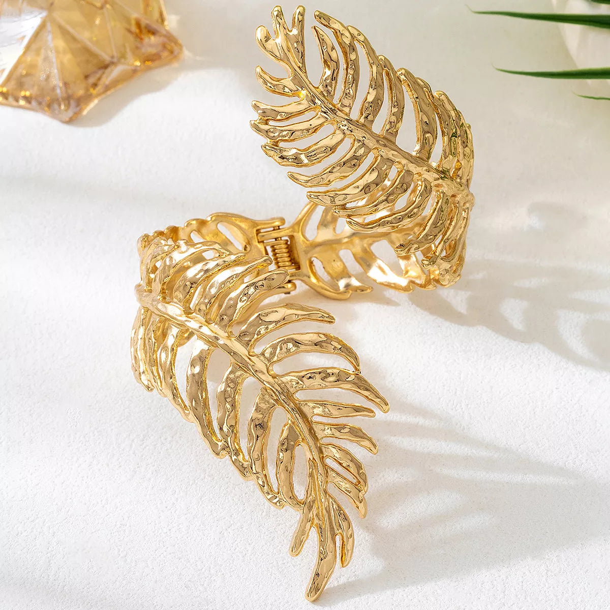 18K gold-plated palm leaf cuff bracelet with hammered texture, worn on wrist — elegant boho statement jewelry from A Whimsical Affair.