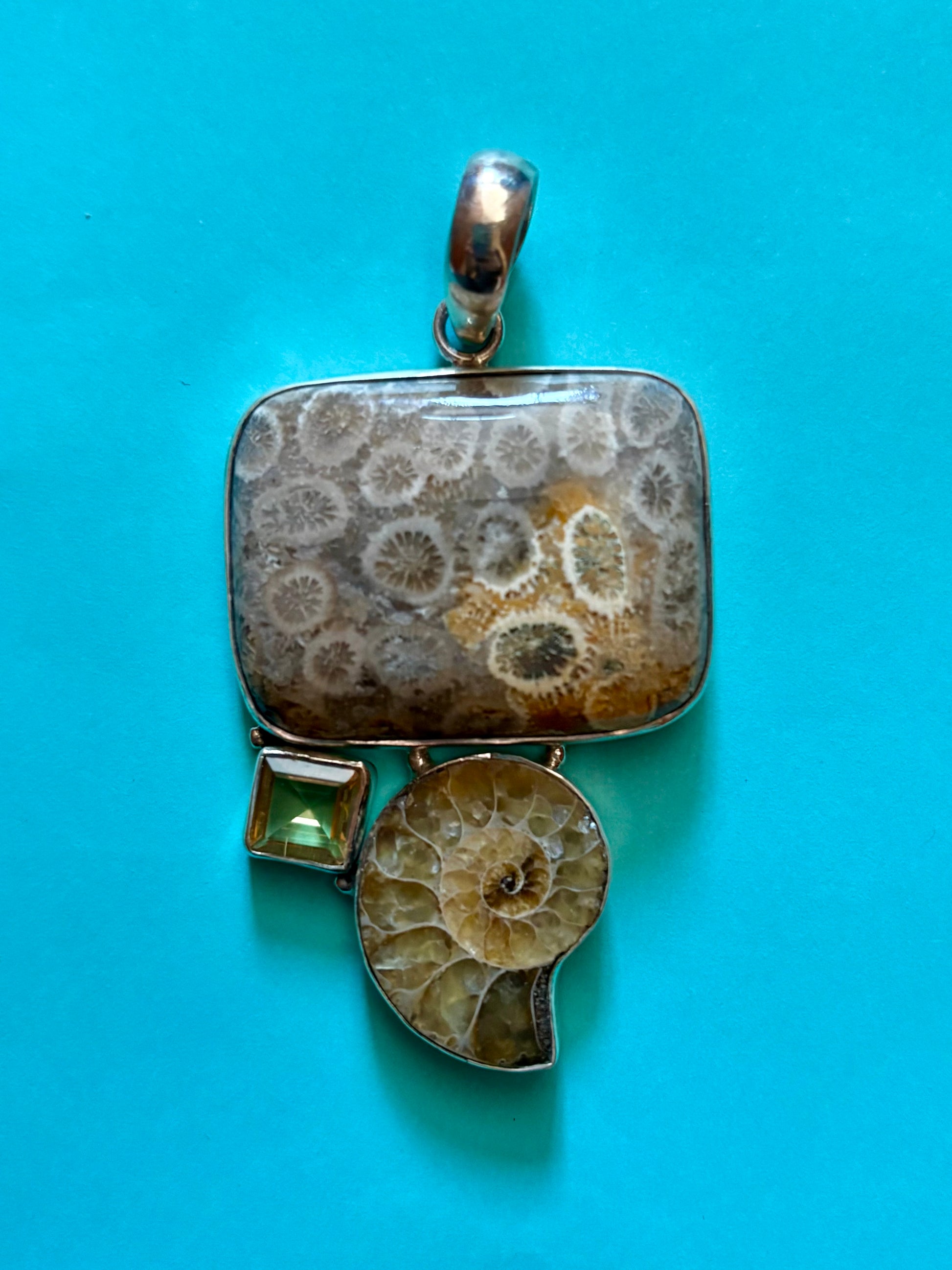 Jewelry pendant with fossil design on a blue background